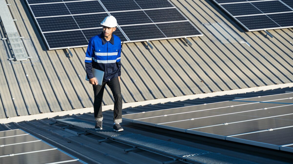 Asian technician installing inspection or repair solar cell panels solar cells on roof top factory