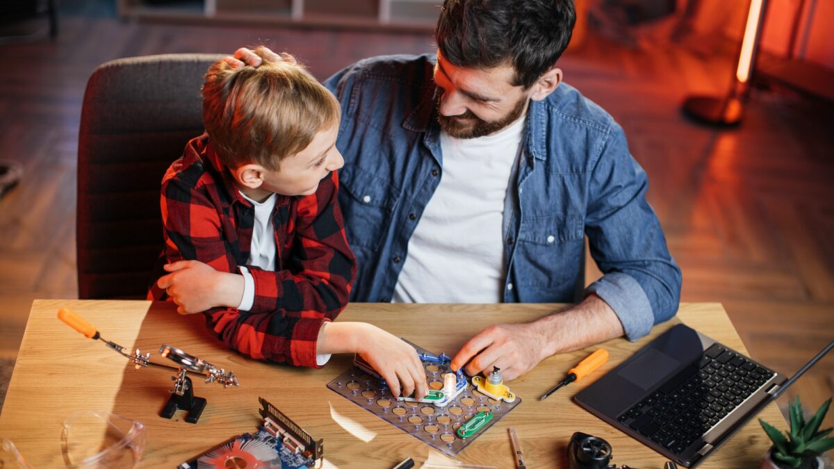Dad with son doing electric circuit experiment at home