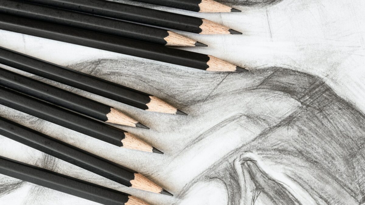 set of graphite pencils on drawing of male face