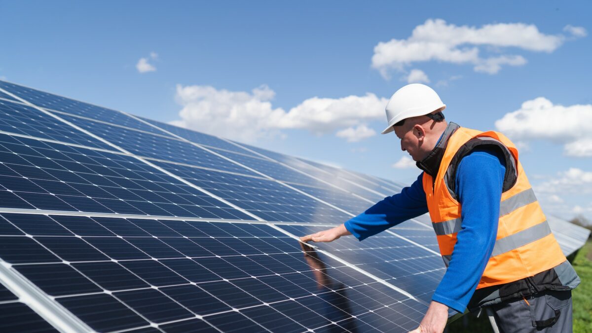 Solar power plant engineer makes a visual inspection of solar panels