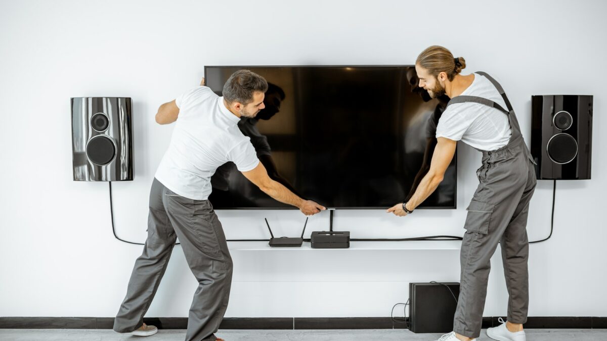 Workmen installing television at home