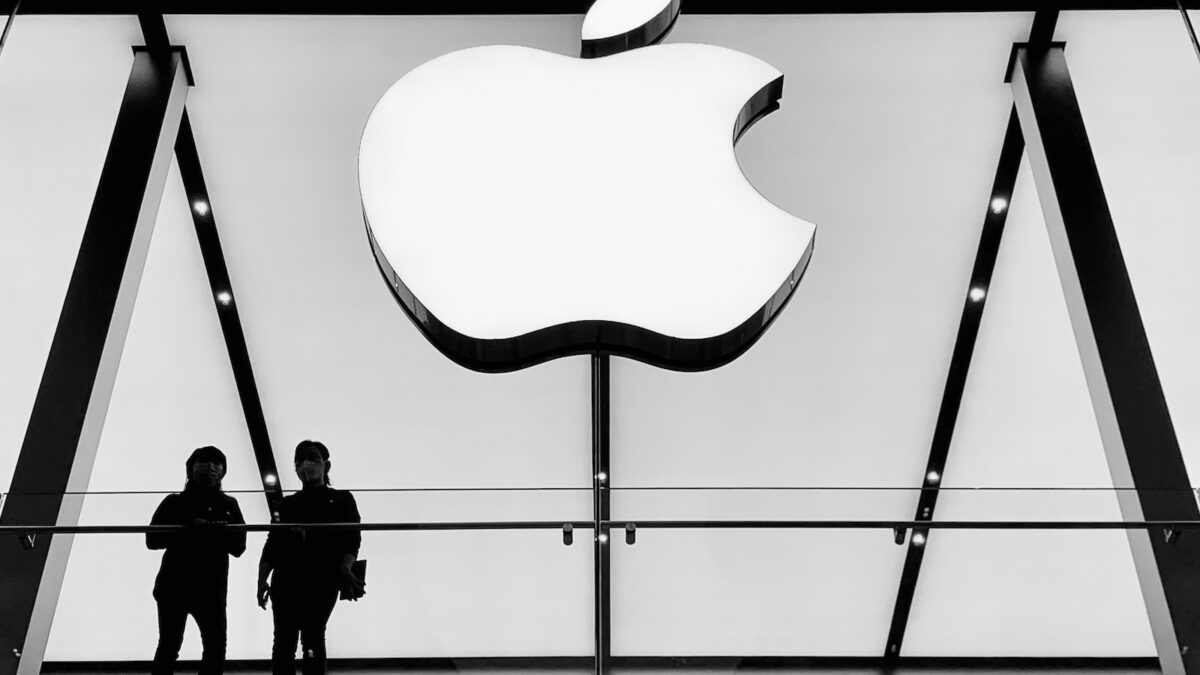 silhouette of people standing near wall with an apple inc logo