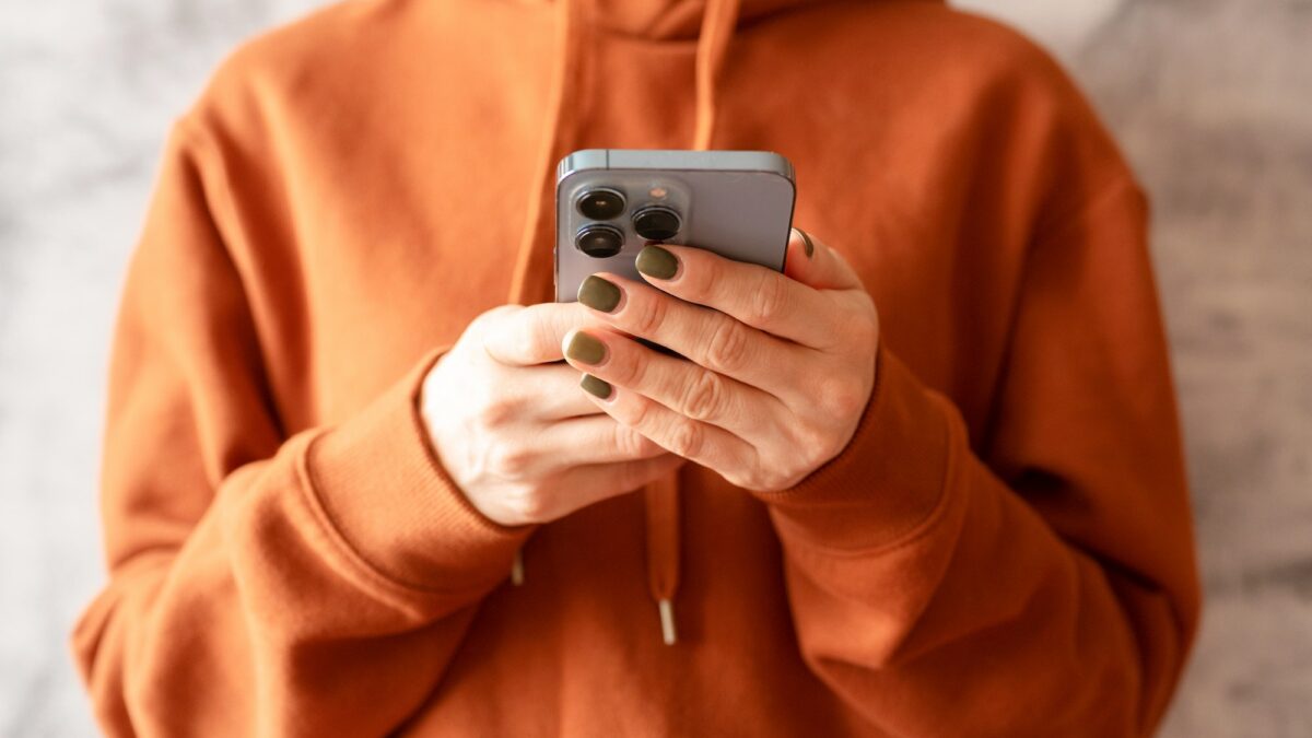 hand holding smartphone iphone texting message. people using mobile phone technology social media