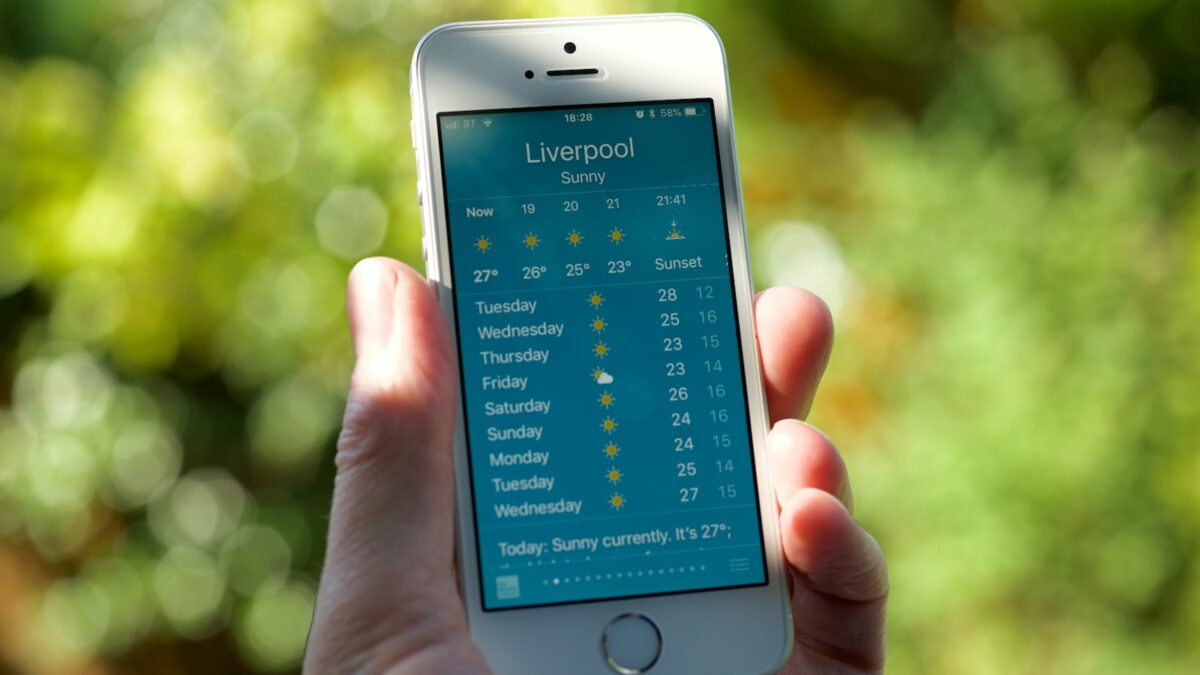 person holding turned on silver iPhone 5s displaying liverpool
