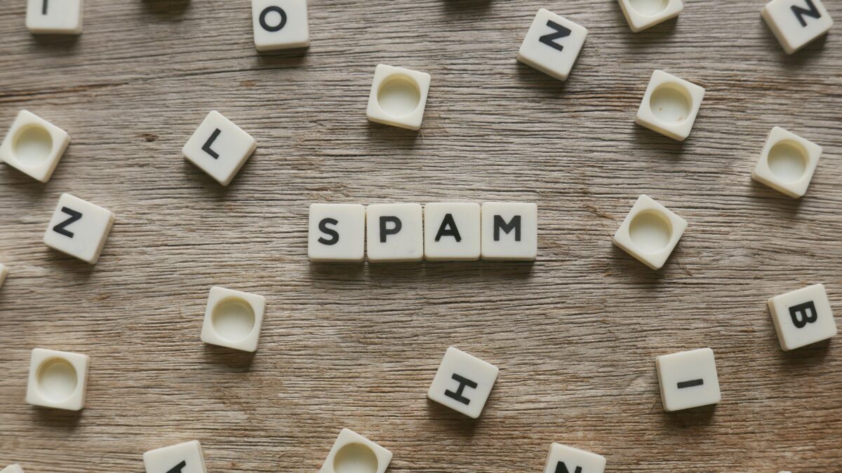 Spam word made of square letter word on wooden background.