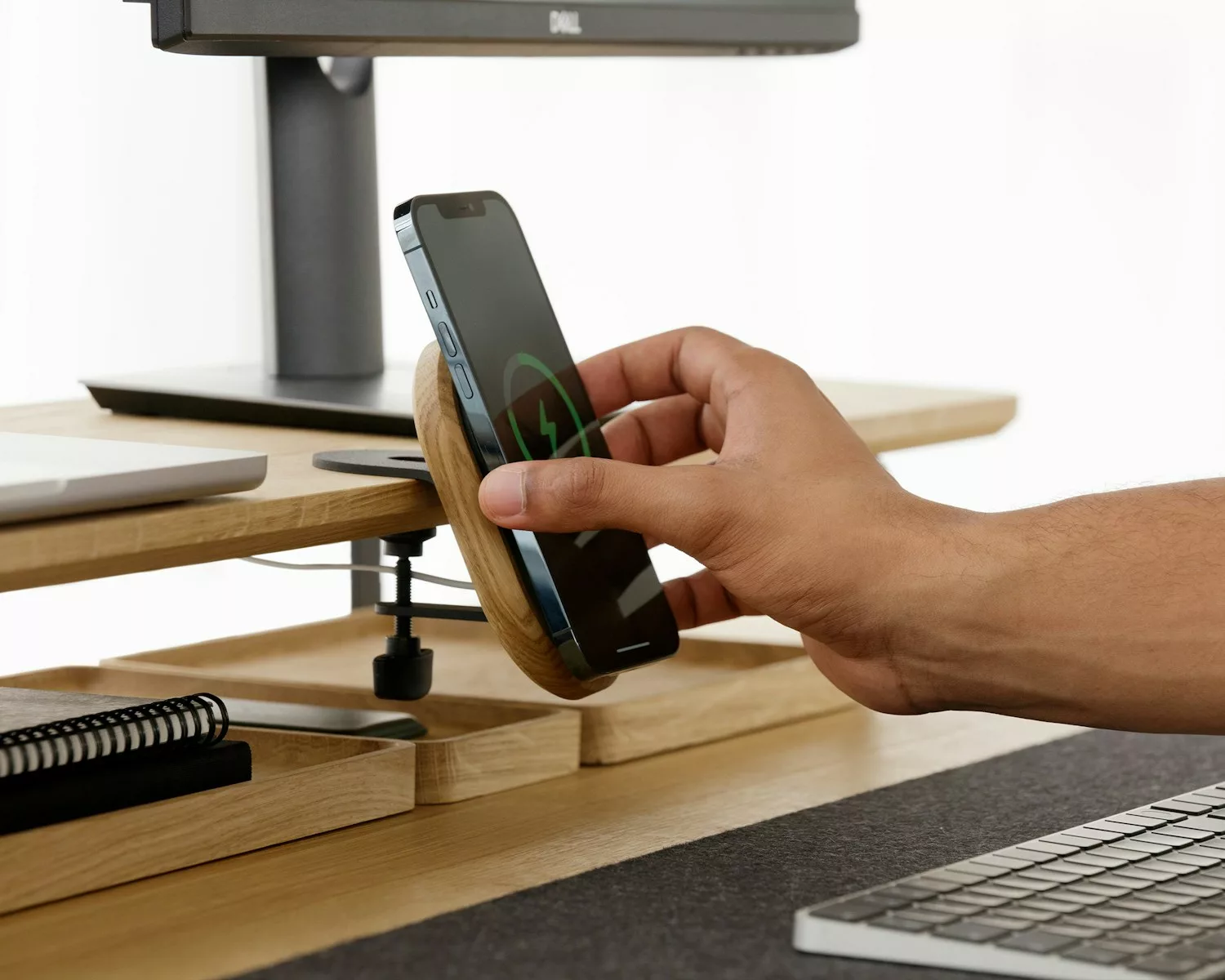 a person holding a cell phone in front of a laptop